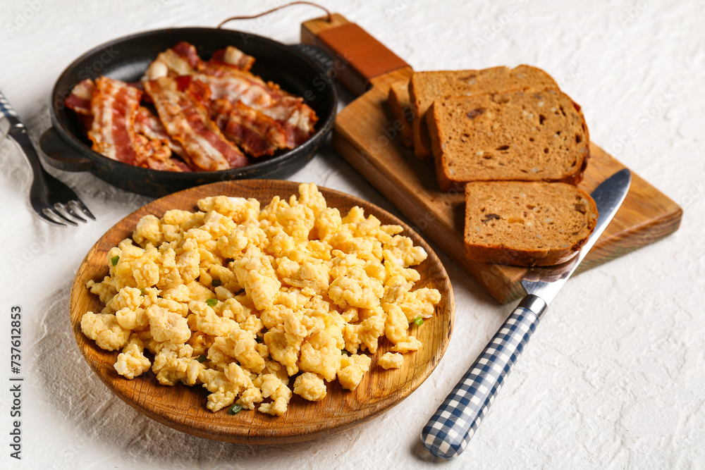 Plate of tasty scrambled eggs on white background