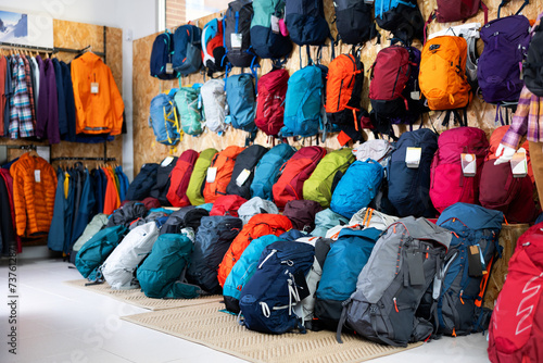 On wall and floor there is showcase with backpack for travelers and tourists - for climbing and hiking, waterproof clothes