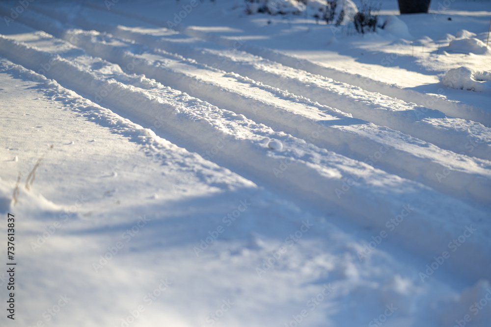 Closeup of car tire tracks through fresh deep snow after Midwest snowstorm Closeup of car tire tracks through fresh deep snow after Midwest snowstorm