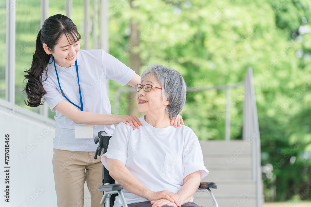 Fototapeta premium 病院・介護施設で肩のリハビリする車椅子に乗る高齢者と介護士(理学療法士・看護師)