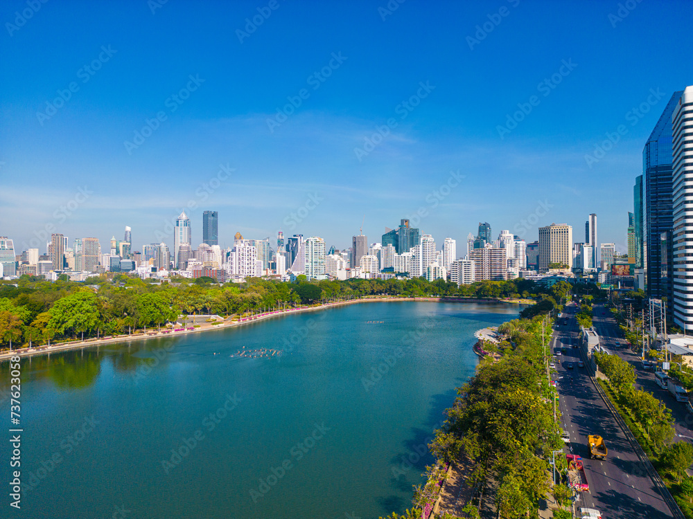 Obraz premium Aerial view modern office building with tropical green tree park in Benchakitti public park downtown