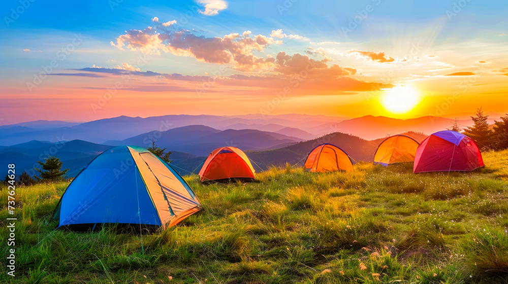 Serene Sunset Camping: Colorful Tents Against the Vibrant Mountainous Landscape.