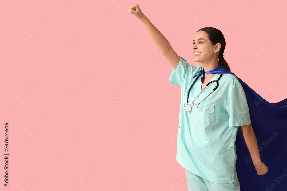 Beautiful female doctor in superhero costume on pink background Beautiful female doctor in superhero costume on pink background