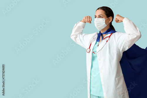 healthcare hero, doctor wearing superhero cape and medical mask showing stren...