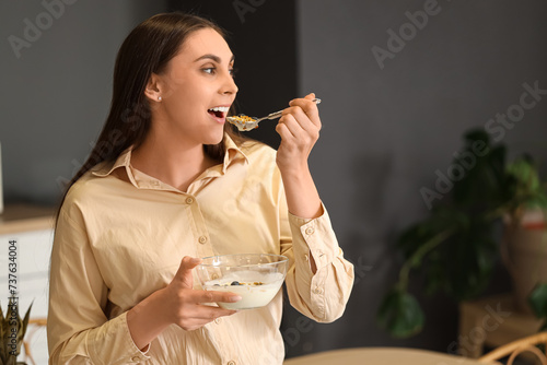 Young woman eating tasty yo...