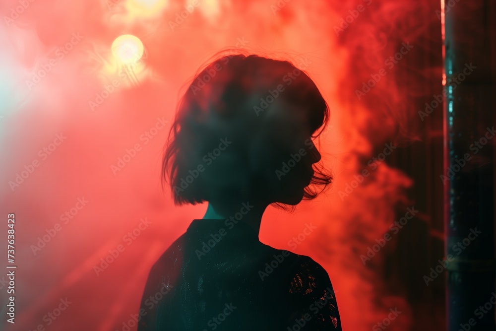 silhouette of a woman with short hair over a red smoky background