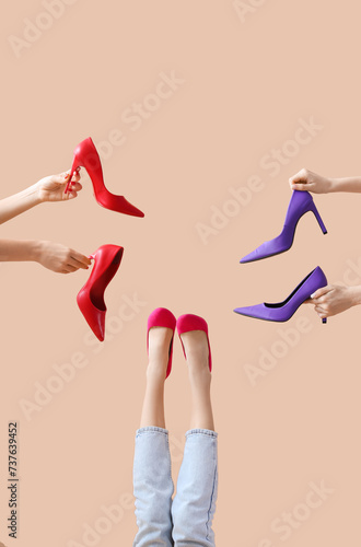 Female hands and legs with shoes sneakers on beige background