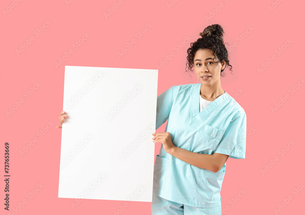 Female African-American medical intern with blank poster on pink background Female African-American medical intern with blank poster on pink background