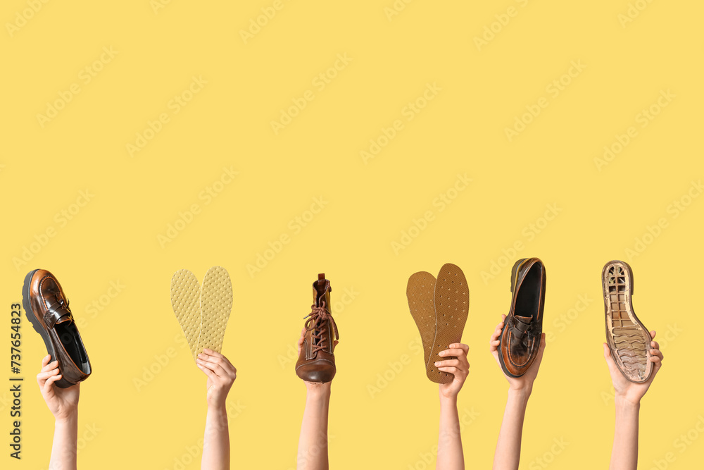Female hands with shoes, sole and insoles on yellow background. Shoe repair concept Female hands with shoes, sole and insoles on yellow background. Shoe repair concept