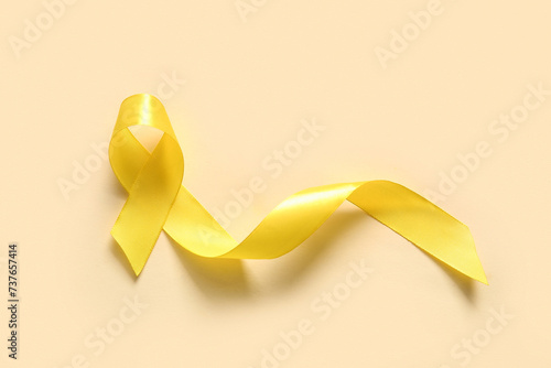 Golden ribbon on beige background. Children cancer awareness concept