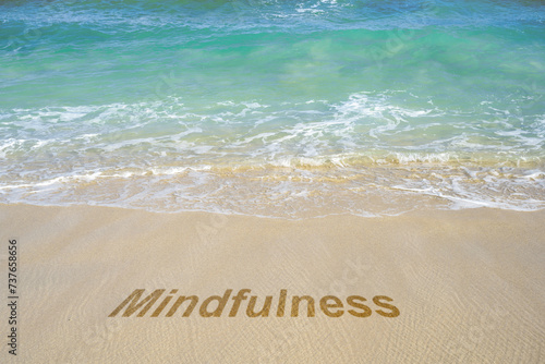 Mindfulness text on the sandy beach with an ocean view