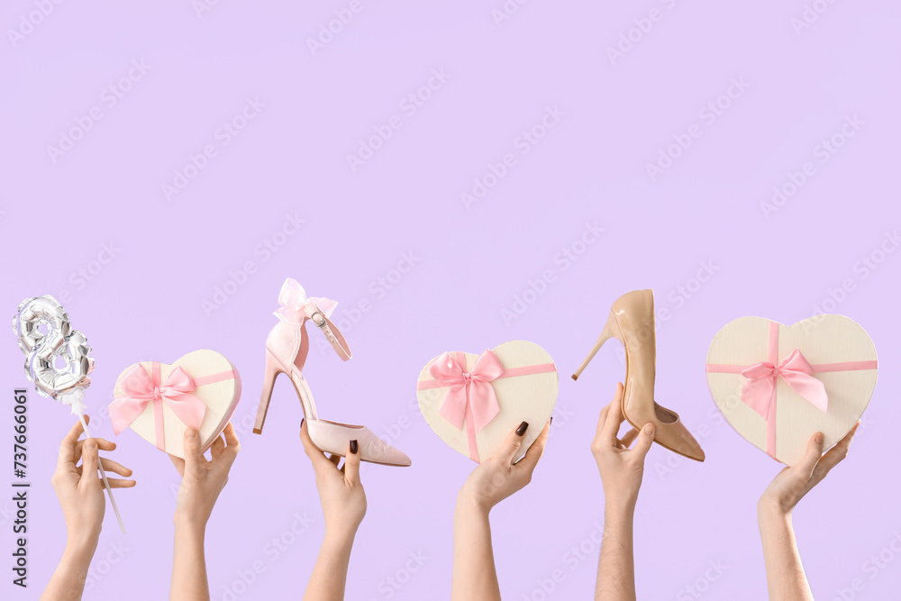 Female hands with high heel shoes, balloon and gift boxes on lilac background. Shopping for International Women's Day