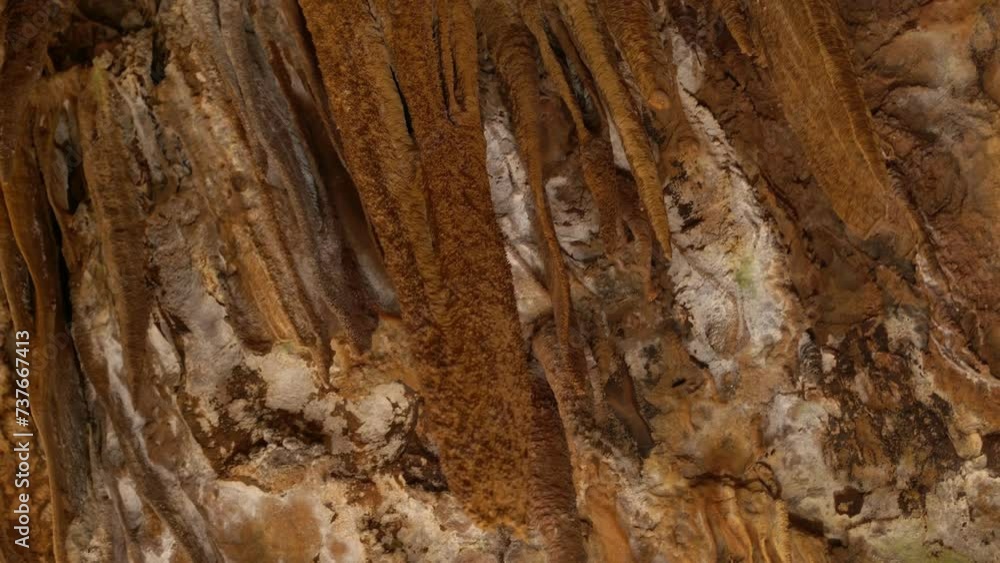 Close-up of brown stalactites in a cave, displaying intricate natural patterns and geological beauty. Close-up of brown stalactites in a cave, displaying intricate natural patterns and geological beauty.