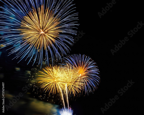 Fireworks in a black night sky, magnificent yellow and blue colors photo