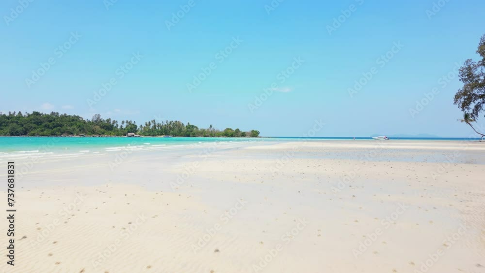 First-person view of white sandy beach and turquoise water on tropical island in Thailand.