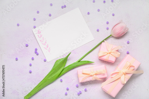 Composition with blank card, tulip and presents on light background