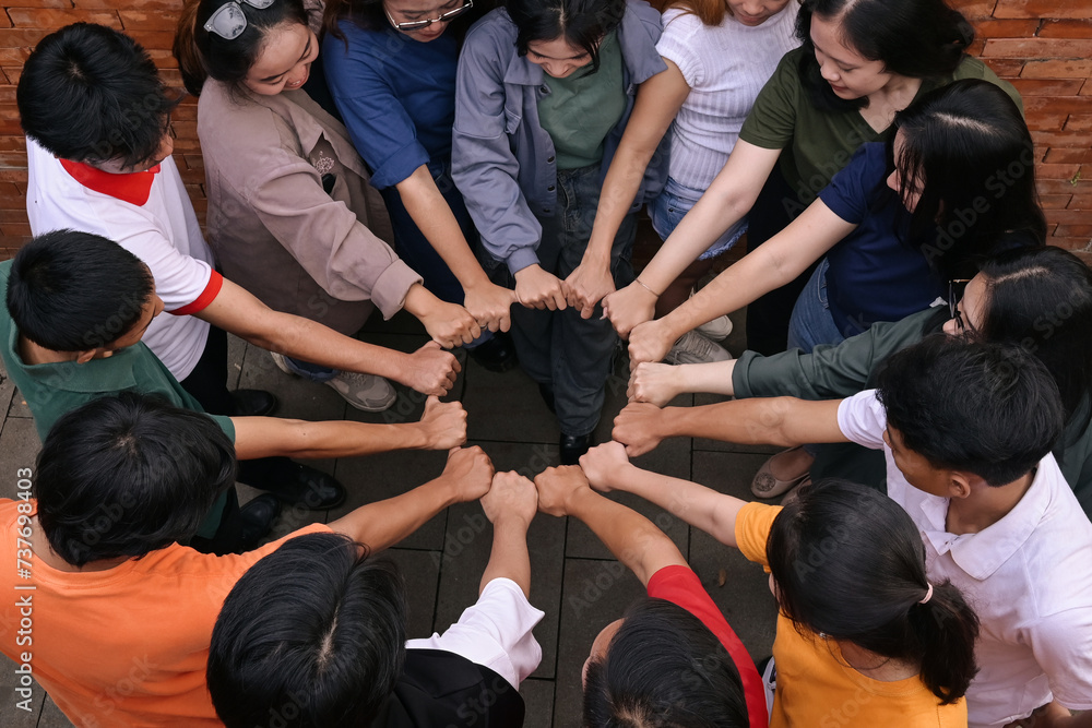 Top view of multi-ethnic people's hand joining their fist to form circle