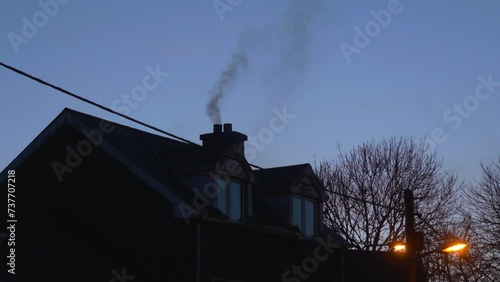 Smoke coming out of the chimney of a house photo