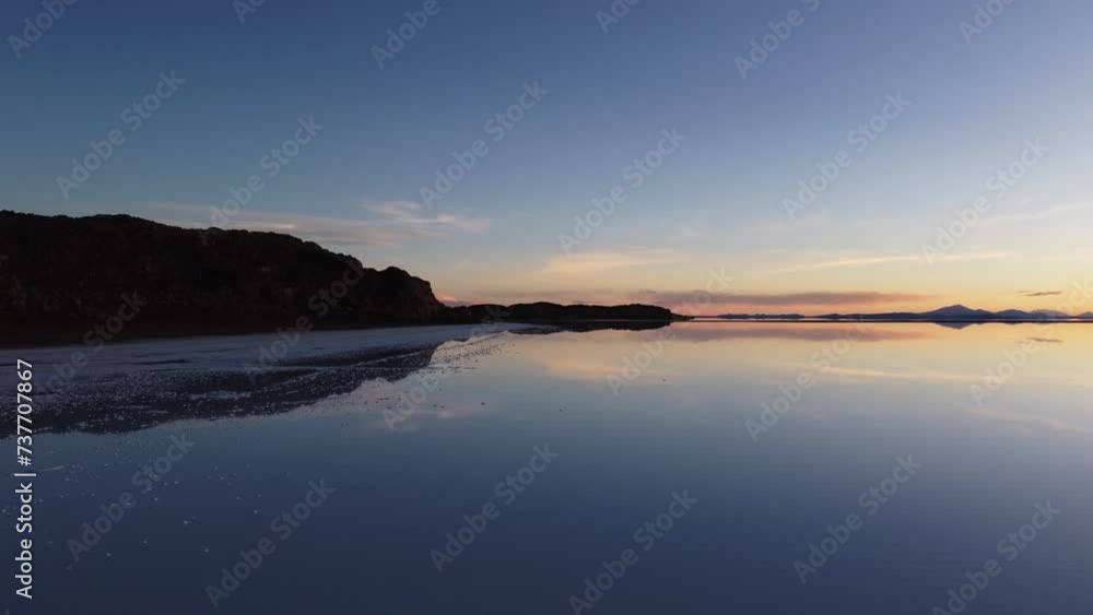 Blue dusk flight along shore of Uyuni Salt Flat lake in high Bolivia Blue dusk flight along shore of Uyuni Salt Flat lake in high Bolivia