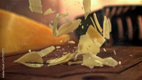 Parmesan cheese falls on a wooden board. Filmed on a high-speed camera at 1000 fps. High quality FullHD footage photo