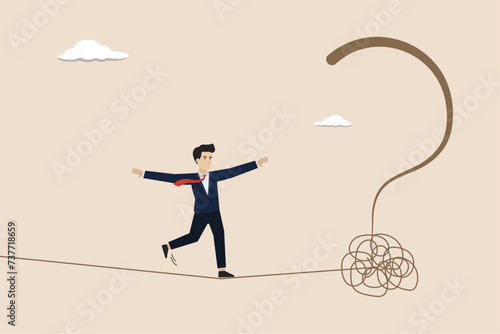 Uncertainty, unknown problem, find out solution for business difficulty, businessman acrobat rope walking to find question mark.