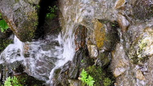 Mountain creek flowing along a stony riverbed photo