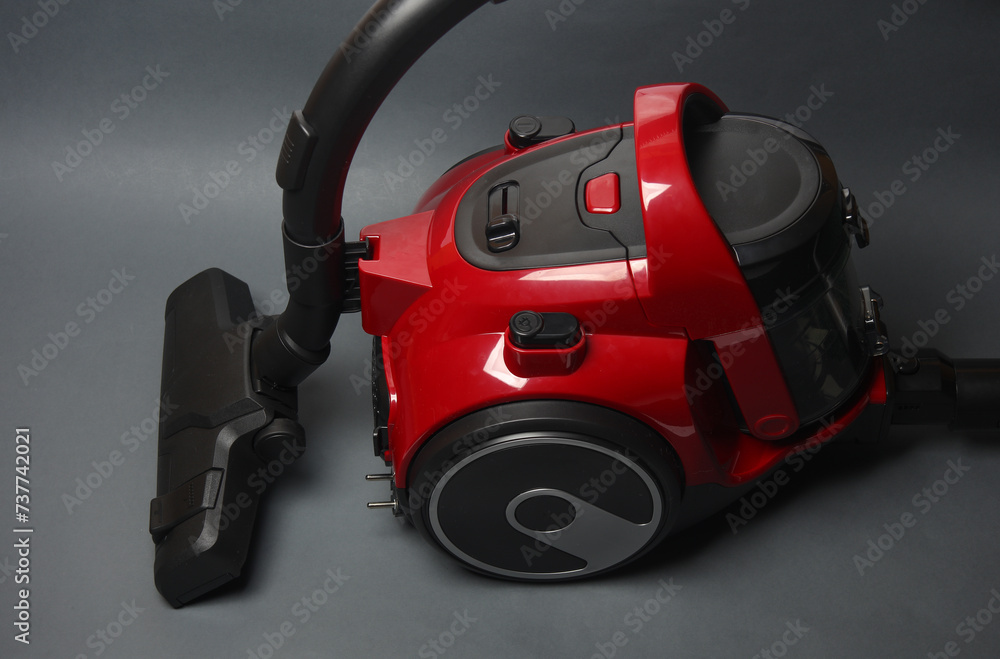 Red modern vacuum cleaner on dark gray background Red modern vacuum cleaner on dark gray background
