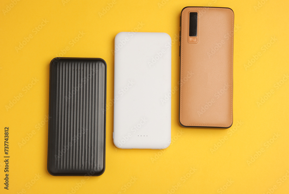 Different power banks (external batteries) on yellow background Different power banks (external batteries) on yellow background