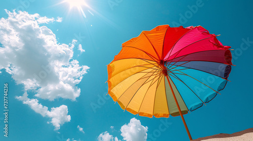 Vibrant Multi-Colored Umbrella Against a Clear Blue Sky with Sunlight  A Symbol of Joy and Brightness