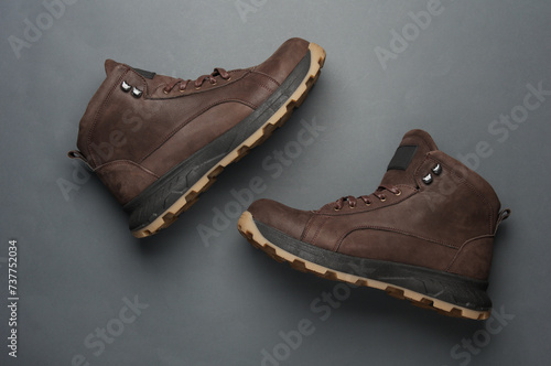 Pair of Brown leather boots on dark gray background. Top view