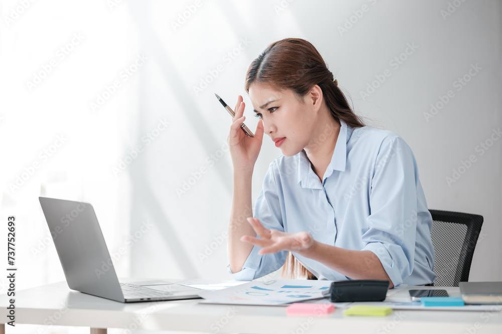 Stressed out Asian Business woman using calculator and laptop for doing math finance on an office desk, tax, report, accounting, statistics, and analytical research concept 