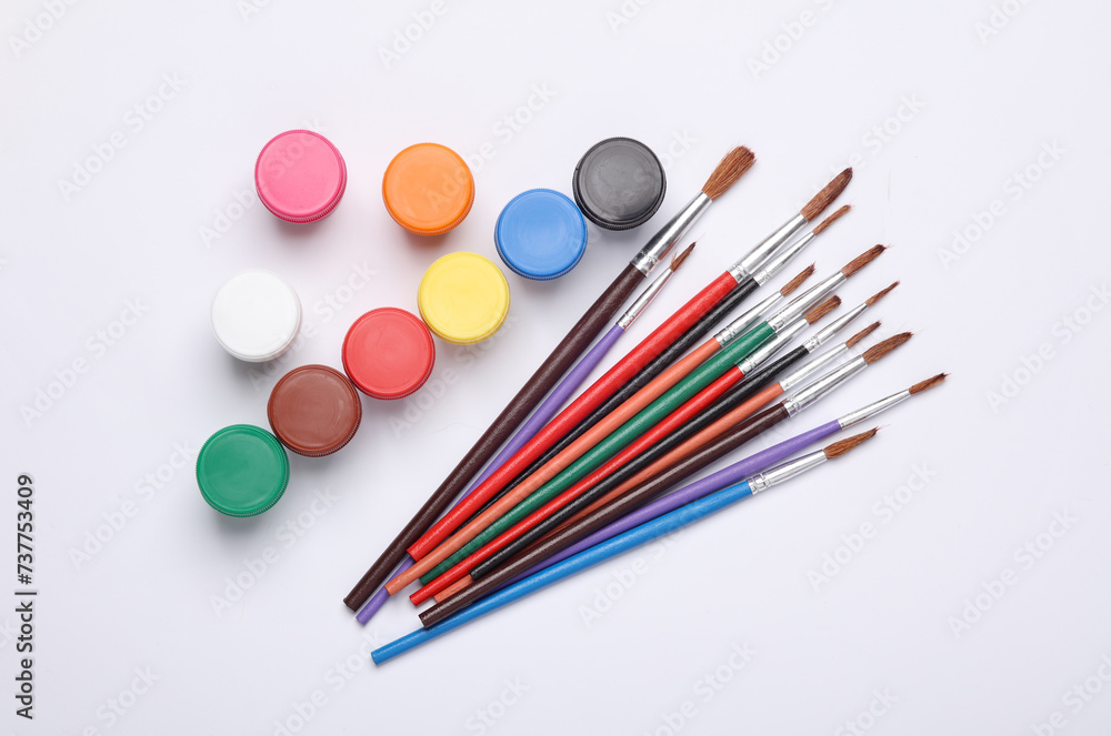Set of gouache paints in bottles with brushes on a white background. Children's creativity Set of gouache paints in bottles with brushes on a white background. Children's creativity