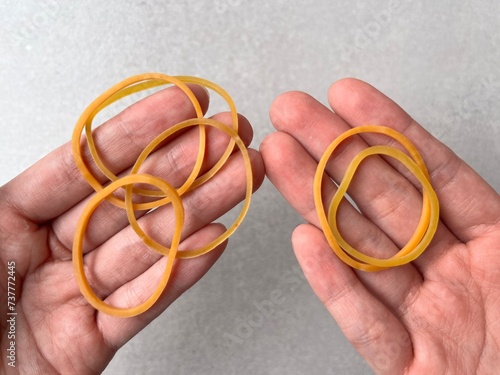 Red rubber band in hand. Elastic bands on hands. Karet gelang kuning. photo