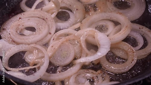 Closeup: Onion rings sizzle, sputter as they fry in hot frying pan oil photo