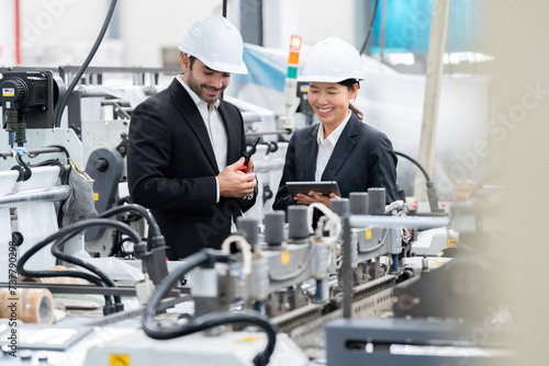 senior official Asian woman and European male architectural engineer It is in the power plants, plastics and steel industries. happy at work Wear a suit and helmet, use a tablet, walkie talkie.