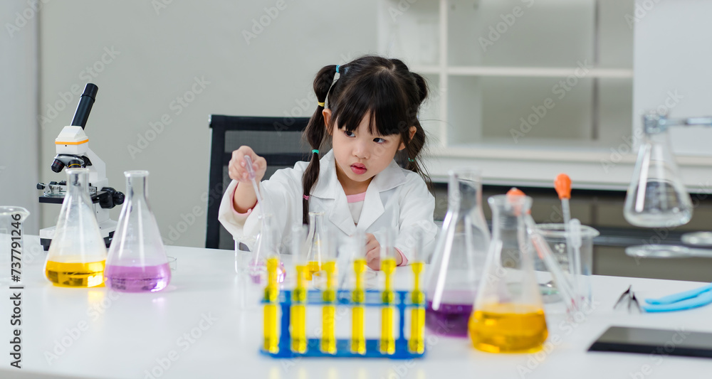 Asian little cute girl students in lab coat making test tube science experiments chemical laboratory in study room at school. Education research and development concept learning kids. Asian little cute girl students in lab coat making test tube science experiments chemical laboratory in study room at school. Education research and development concept learning kids.