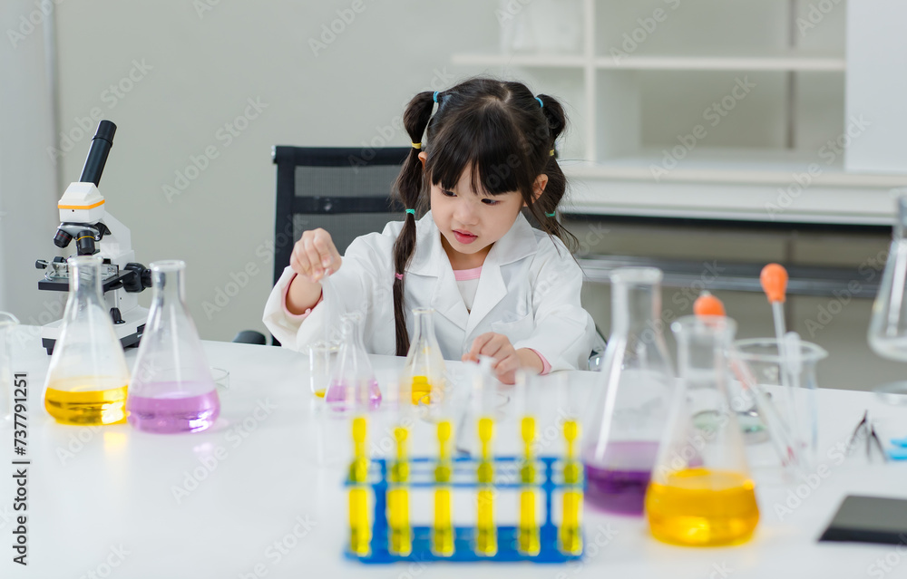 Asian little cute girl students in lab coat making test tube science experiments chemical laboratory in study room at school. Education research and development concept learning kids. Asian little cute girl students in lab coat making test tube science experiments chemical laboratory in study room at school. Education research and development concept learning kids.