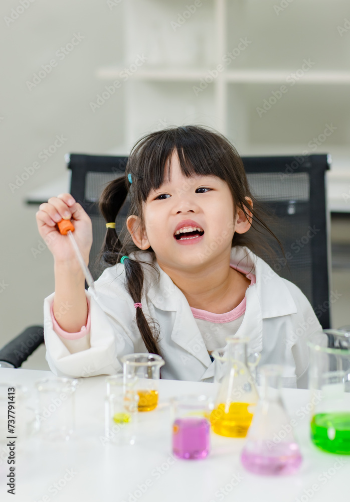 Asian little cute girl students in lab coat making test tube science experiments chemical laboratory in study room at school. Education research and development concept learning kids. Asian little cute girl students in lab coat making test tube science experiments chemical laboratory in study room at school. Education research and development concept learning kids.