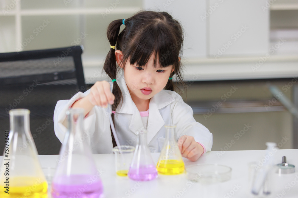 Asian little cute girl students in lab coat making test tube science experiments chemical laboratory in study room at school. Education research and development concept learning kids. Asian little cute girl students in lab coat making test tube science experiments chemical laboratory in study room at school. Education research and development concept learning kids.