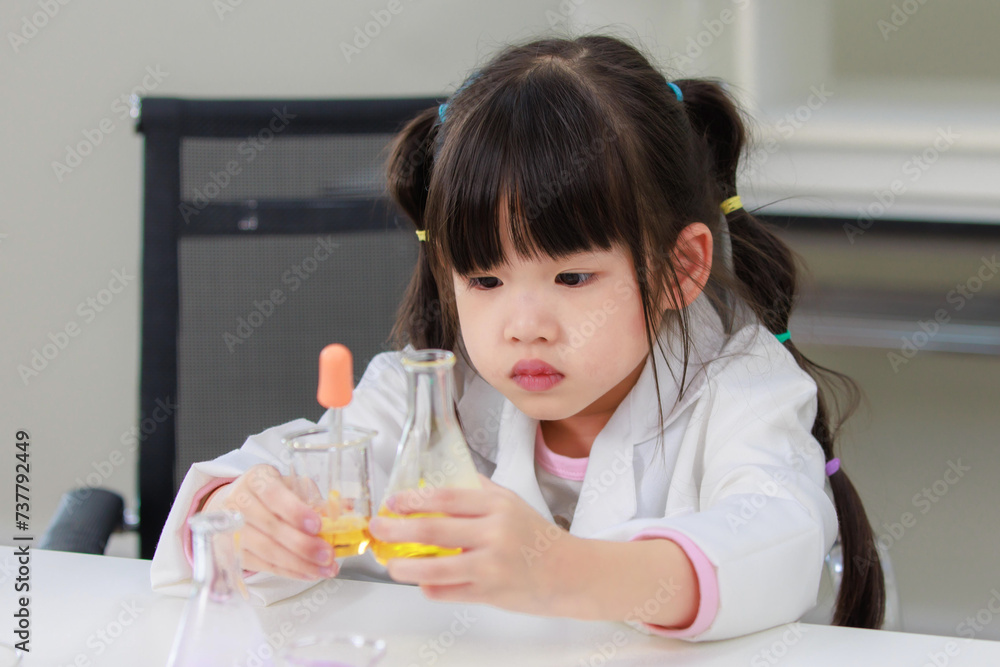 Asian little cute girl students in lab coat thinking making test tube science experiments chemical laboratory in study room at school. Education research and development concept learning kids. Asian little cute girl students in lab coat thinking making test tube science experiments chemical laboratory in study room at school. Education research and development concept learning kids.