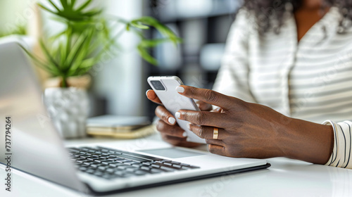 Empowered Businesswoman Using Technology, Laptop and Smartphone at a Modern Office Desk, Connectivity in Focus