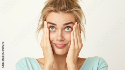 Surprised young woman holding face in hands