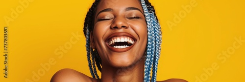 Portrait of laughing african american woman on yellow background