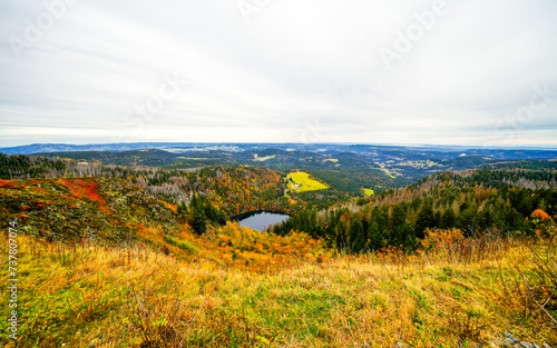 Autumnal landscape on the Feldberg in the Black Forest with a view of the Feldsee and the surrounding nature with forests and hills. 