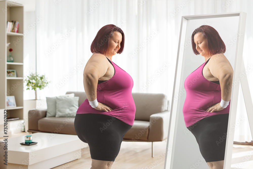 Plus size woman in sportswear standing in front of a mirror