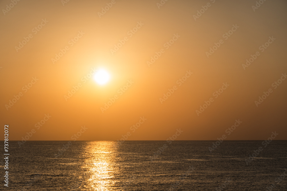very bright white sun with reflection in the water during sunrise