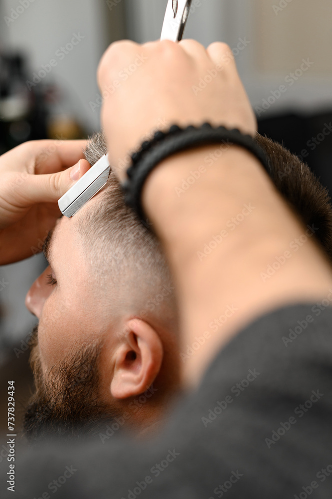The barber makes the outline with a dangerous razor the undercut haircut The barber makes the outline with a dangerous razor the undercut haircut