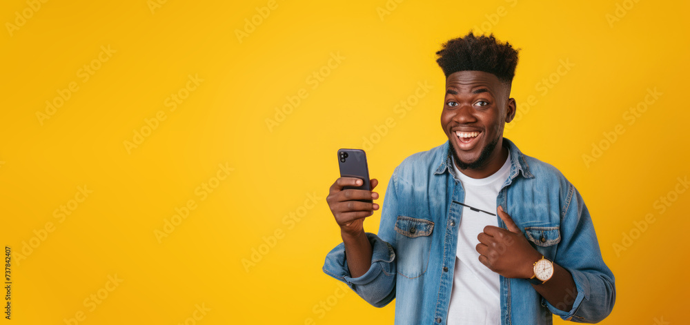 Excited Black Man Holding a Smartphone on yellow background banner 