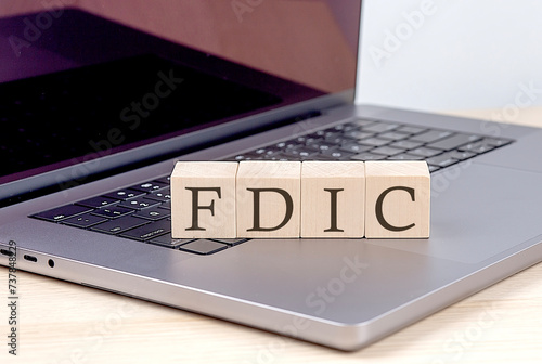 FDIC word on wooden block on laptop, business concept photo