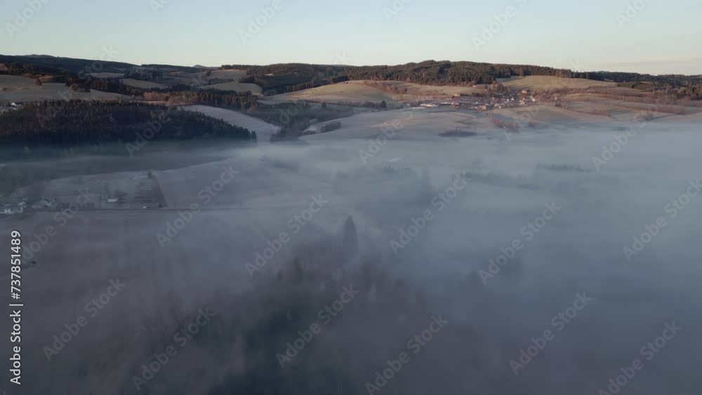 An aerial view of the fog-shrouded Sumava landscape with hills, forests and fields, a peaceful and natural scene. An aerial view of the fog-shrouded Sumava landscape with hills, forests and fields, a peaceful and natural scene.